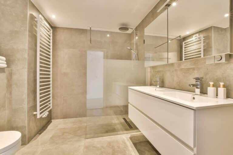 Vue d’une salle de bain à Amiens avec douche à l’italienne, double vasque et carrelage gris clair.