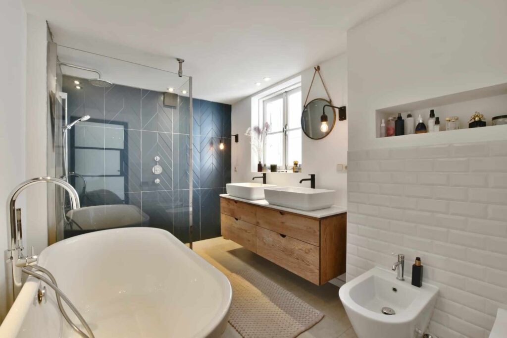 Salle de bain à Amiens avec vasque sur plan, double miroir, bidet et carrelage gris foncé.
