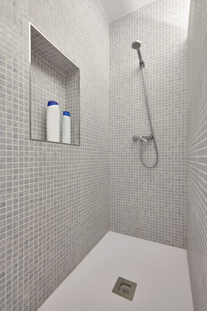 Douche avec savon et shampoing dans salle de bain moderne