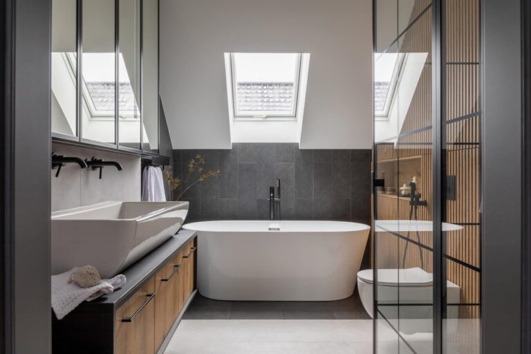 Salle de bain moderne à Amiens avec baignoire îlot sous puits de lumière et meuble en bois.